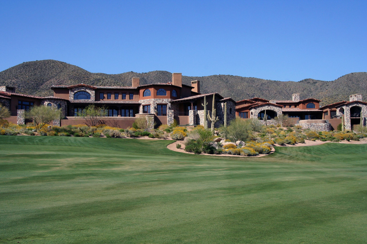 Desert estate homes along a golf course below the mountains